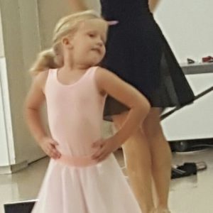 Young ballet dancer posing with instructor