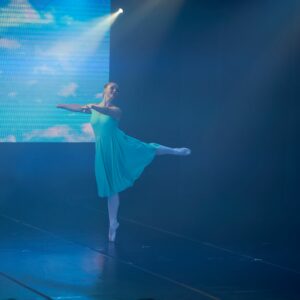 Teenage Ballerina in Blue Dress Performing On Stage
